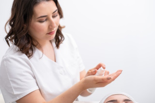 Beauty Ritual - Friseurin bei der Anwendung einer Gesichtsmaske